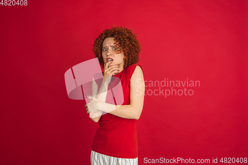 Image of Caucasian woman\'s portrait isolated over red studio background with copyspace