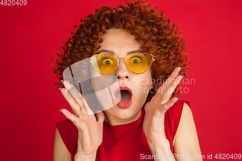 Image of Caucasian woman\'s portrait isolated over red studio background with copyspace