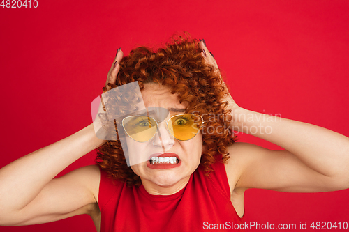 Image of Caucasian woman\'s portrait isolated over red studio background with copyspace