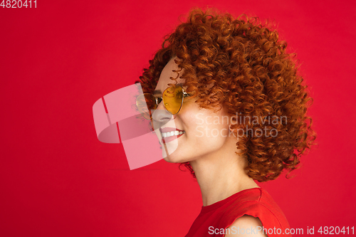 Image of Caucasian woman\'s portrait isolated over red studio background with copyspace