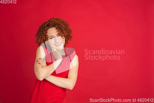 Image of Caucasian woman\'s portrait isolated over red studio background with copyspace