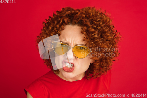 Image of Caucasian woman\'s portrait isolated over red studio background with copyspace
