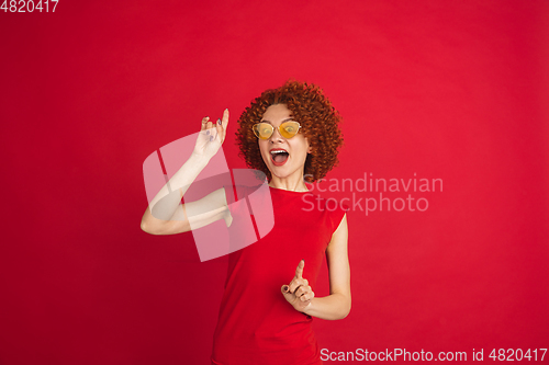 Image of Caucasian woman\'s portrait isolated over red studio background with copyspace