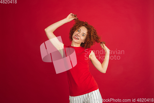 Image of Caucasian woman\'s portrait isolated over red studio background with copyspace