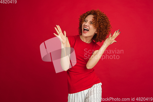 Image of Caucasian woman\'s portrait isolated over red studio background with copyspace