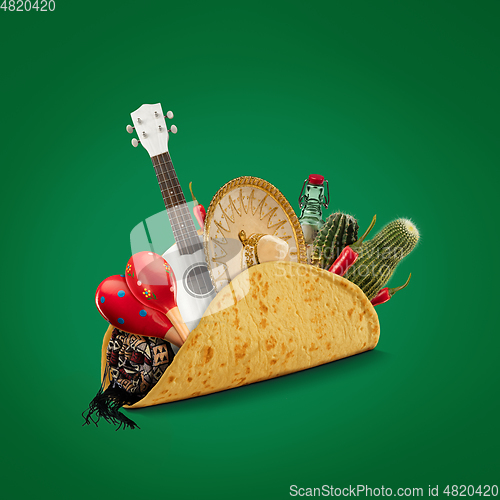 Image of Fresh and tasty taco filled with Sombrero, Ukulele, Maracas, cactus, drink on green background.