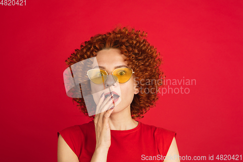 Image of Caucasian woman\'s portrait isolated over red studio background with copyspace