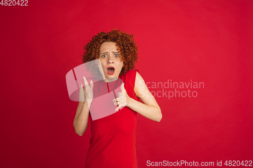 Image of Caucasian woman\'s portrait isolated over red studio background with copyspace