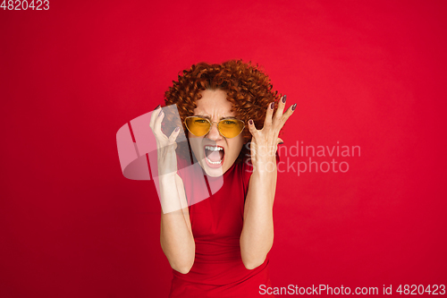 Image of Caucasian woman\'s portrait isolated over red studio background with copyspace
