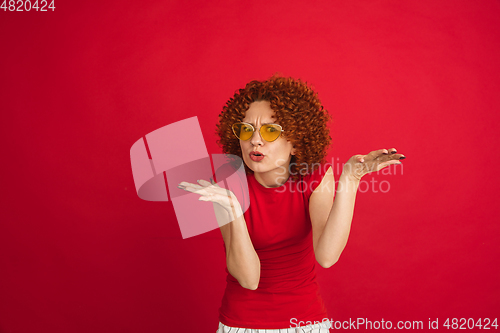 Image of Caucasian woman\'s portrait isolated over red studio background with copyspace