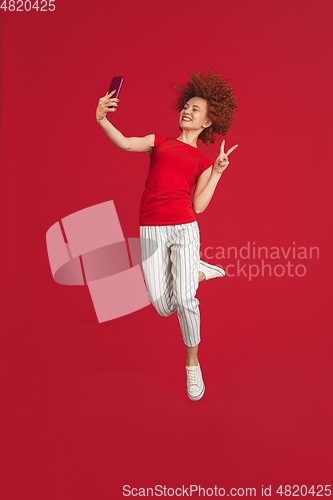 Image of Caucasian woman\'s portrait isolated over red studio background with copyspace