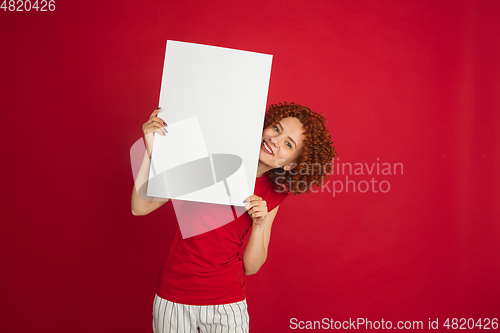 Image of Caucasian woman\'s portrait isolated over red studio background with copyspace