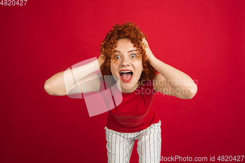 Image of Caucasian woman\'s portrait isolated over red studio background with copyspace