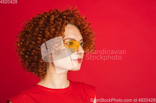 Image of Caucasian woman\'s portrait isolated over red studio background with copyspace