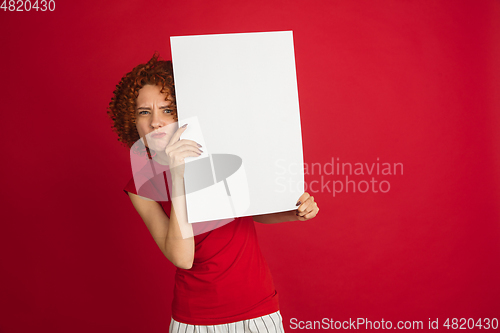 Image of Caucasian woman\'s portrait isolated over red studio background with copyspace