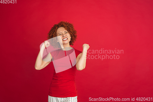 Image of Caucasian woman\'s portrait isolated over red studio background with copyspace