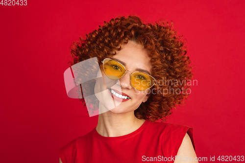 Image of Caucasian woman\'s portrait isolated over red studio background with copyspace