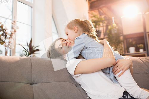 Image of Family time. Mother and daughter having time together at home, look happy and sincere