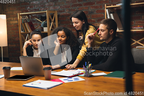 Image of Colleagues working together in modern office using devices and gadgets during creative meeting