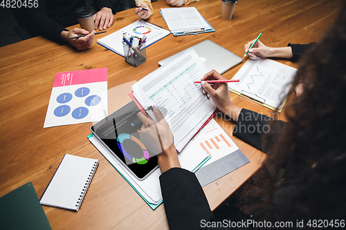 Image of Colleagues working together in modern office using devices and gadgets during creative meeting