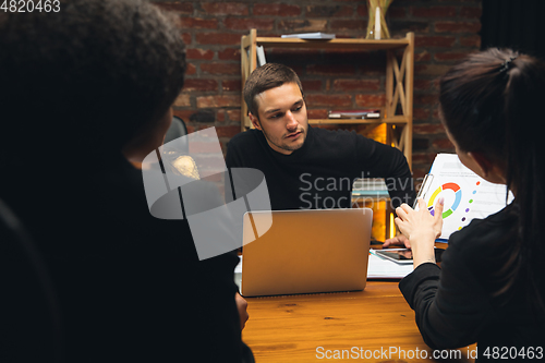 Image of Colleagues working together in modern office using devices and gadgets during creative meeting