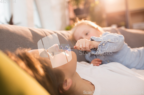 Image of Family time. Mother and daughter having time together at home, look happy and sincere