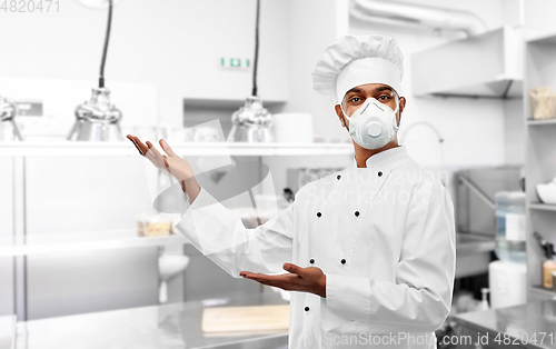 Image of male chef in respirator at restaurant kitchen