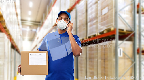 Image of delivery man in mask with smartphone and parcel