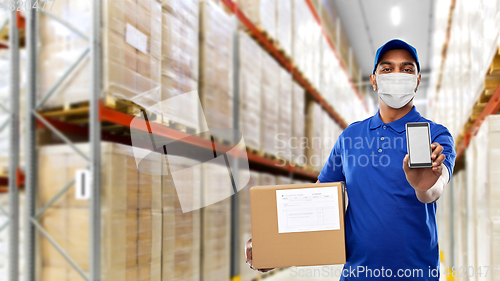 Image of delivery man in mask with cellphone and parcel box