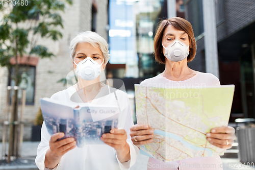 Image of senior women with city guide and map in face masks