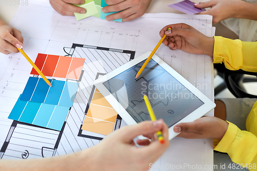 Image of hands with blueprint, tablet pc and color samples