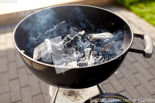 Image of charcoal smoldering in brazier outdoors