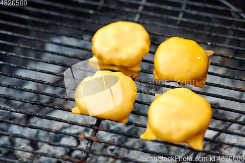 Image of close up of meat cutlet with cheese on grill