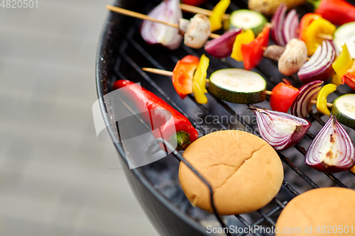 Image of vegetables and burger buns roasting on grill