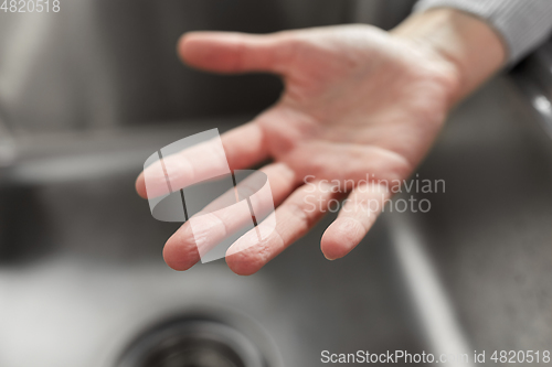 Image of close up of clean woman's hand over kitchen sink