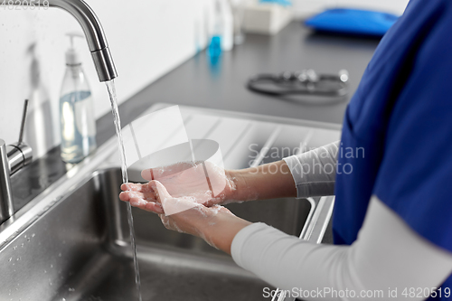 Image of doctor or nurse washing hands with liquid soap