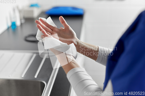 Image of doctor or nurse drying hands with paper tissue