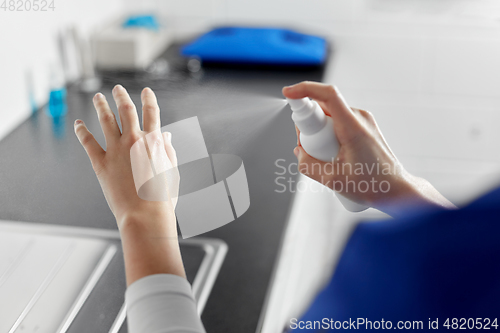 Image of doctor or nurse spraying hand sanitizer