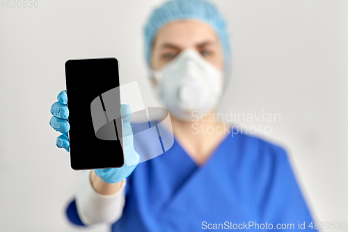 Image of doctor in goggles and face mask with smartphone