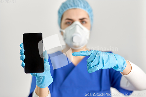 Image of doctor in goggles and face mask with smartphone