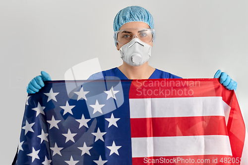 Image of doctor in goggles and mask holding flag of america