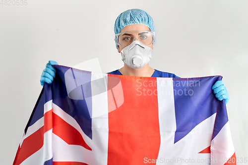 Image of doctor in goggles and mask holding flag of america