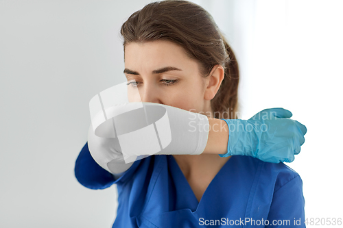 Image of doctor or nurse coughing covering mouth with elbow