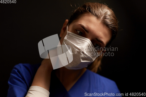 Image of tired female doctor or nurse in medical face mask