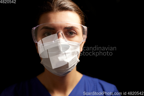 Image of female doctor or nurse in goggles and face mask