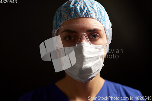 Image of female doctor or nurse in goggles and face mask