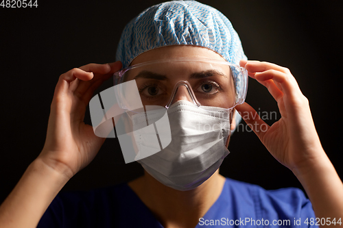 Image of female doctor or nurse in goggles and face mask