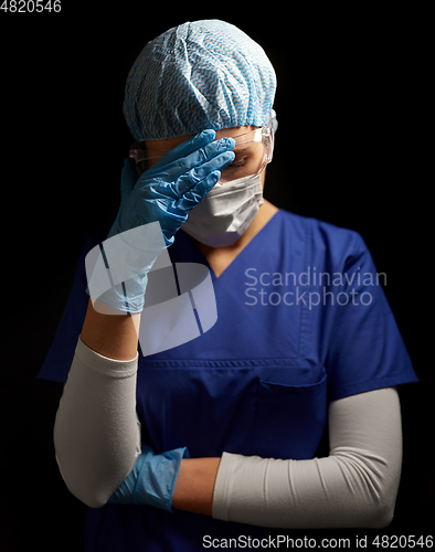 Image of sad doctor or nurse in goggles and face mask