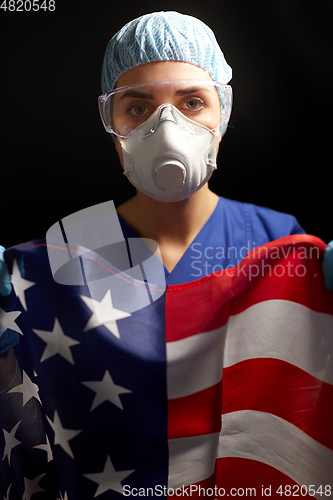 Image of doctor in goggles and mask holding flag of america