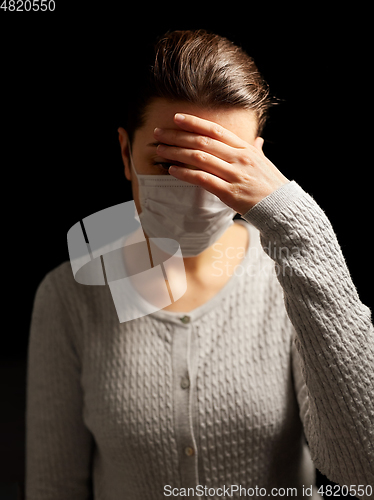 Image of sick young woman in protective medical face mask